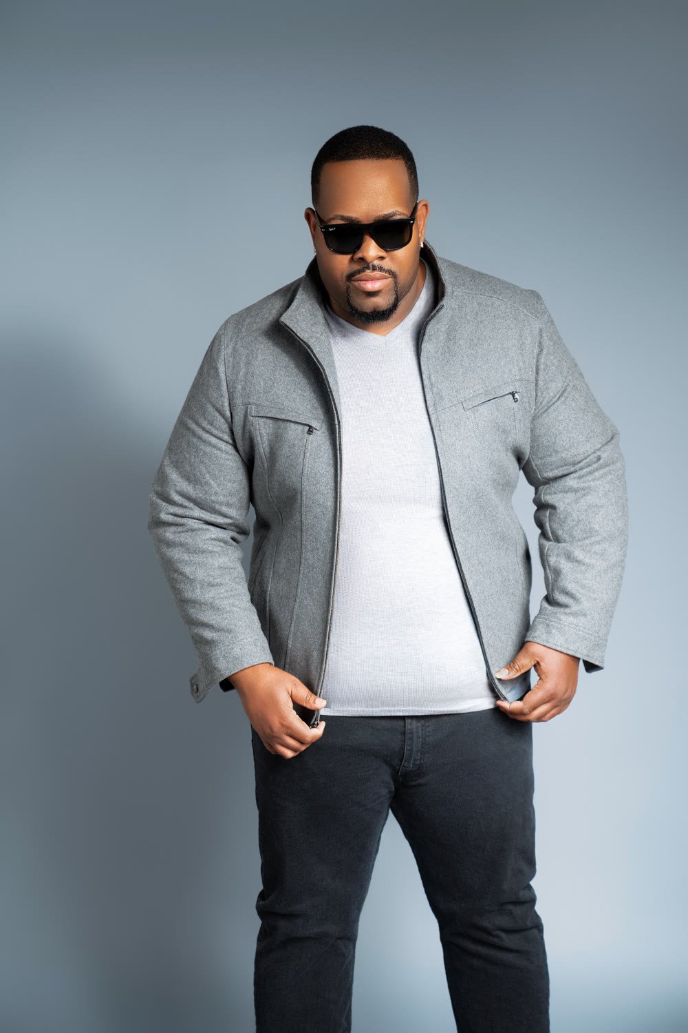 Prince Charm in a grey jacket and dark sunglasses